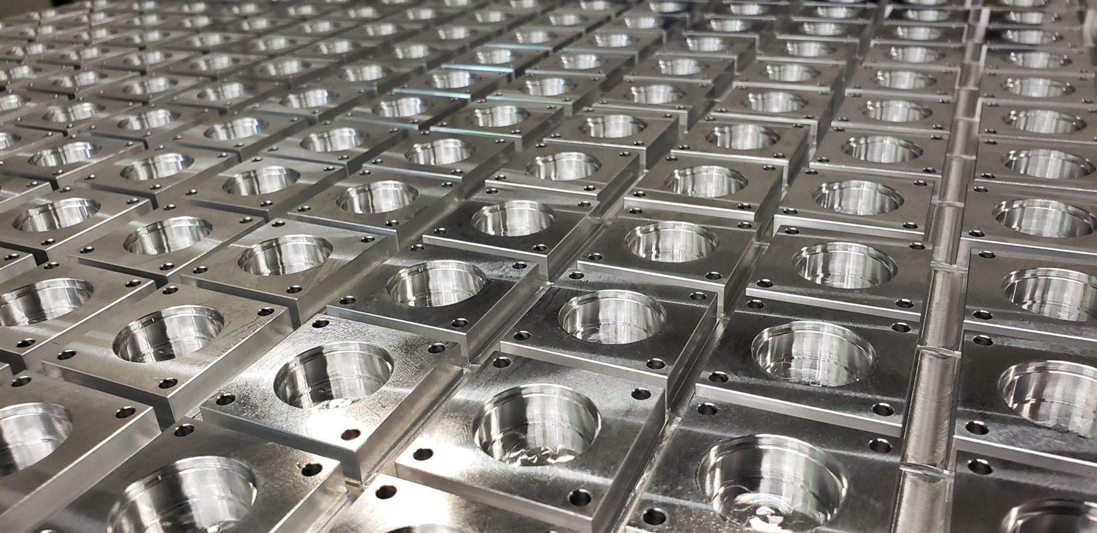 Rows of matching machined housings from Reformed Manufacturing